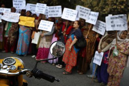 Un polic&iacute;a vigila desde su motocicleta una protesta de mujeres en Nueva Delhi.