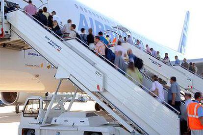 Empleados de Airbus suben al avión para realizar el primer vuelo con pasajeros del A-380.