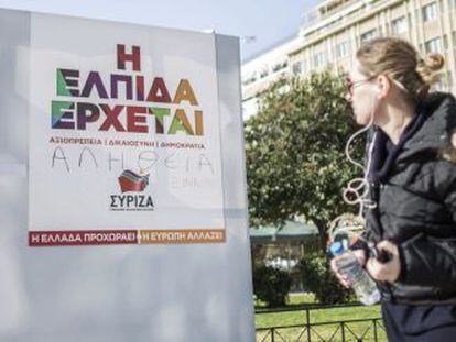 Una joven observa un cartel electoral del l&iacute;der de Syiza, Alexis Tsipras, en el centro de Atenas (Grecia) el viernes 23 de enero de 2015. 