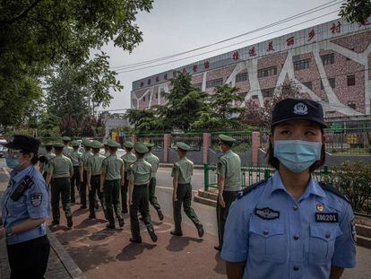 Agentes de policía chinos impiden la entrada al edificio del mercado Xinfadi, en Pekín, donde se ha detectado un brote de Covid-19.