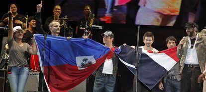 Milly Quezada, Miguel Bosé, Alejandro Sanz, Juanes, Luis Fonsi y Juan Luis Guerra sostienen la bandera de Haití y de la República Dominicana al final del concierto.