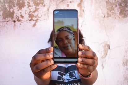 Glad oculta su rostro tras una fotografía de su madre, a quien envía dinero para subsistir en el Congo.