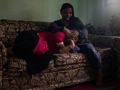 Sunita Danwuar (derecha), de 41 años, cubre la cara de T., de 30, ambas supervivientes del tráfico de personas. Las dos mujeres posan en la casa de Danwuar en Katmandú, capital de Nepal.