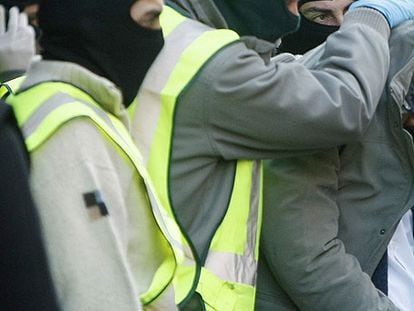 Tapado con su chaqueta, un arrestado ayer en Barcelona.