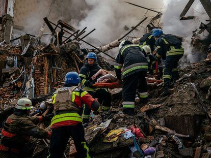Bomberos ucranios sacan el cuerpo de una mujer de entre los escombros de un edificio en Zaporiyia este jueves.