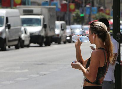 Una mujer bebe agua mientras espera para cruzar la Gran Vía de Madrid, el 16 de junio del 2017.
