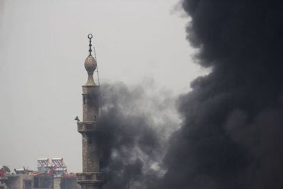 Humo emerge de un minarete en una zona de Damsco, en un d&iacute;a de enfrentamientos entre los rebeldes y las fuerzas de El Asad.