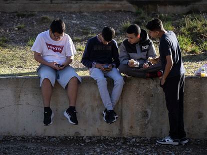 Varios alumnos utilizan sus teléfonos móviles durante el recreo en un instituto del área de Barcelona.