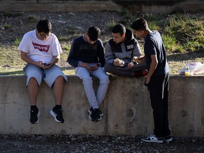 Varios alumnos utilizan sus teléfonos móviles durante el recreo en un instituto del área de Barcelona.