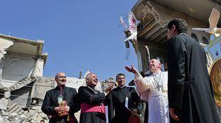 A handout picture released by the Vatican media office, shows Pope Francis, releasing a white dove at a square near the ruins of the Syriac Catholic Church of the Immaculate Conception (al-Tahira-l-Kubra), in the old city of Iraq's northern Mosul on March 7, 2021. - Pope Francis, on his historic Iraq tour, visits today Christian communities that endured the brutality of the Islamic State group until the jihadists' "caliphate" was defeated three years ago (Photo by - / VATICAN MEDIA / AFP) / XGTY / === RESTRICTED TO EDITORIAL USE - MANDATORY CREDIT "AFP PHOTO / HO / VATICAN MEDIA" - NO MARKETING NO ADVERTISING CAMPAIGNS - DISTRIBUTED AS A SERVICE TO CLIENTS ===