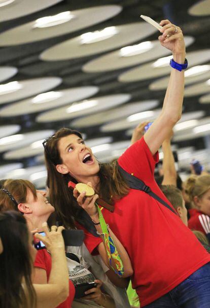 La campeona olímpica Ruth Beitia, medalla de oro en salto de altura, se hace un selfi con los aficionados que esperaban en el Aeropuerto Adolfo Suárez Madrid-Barajas la llegada de la delegación española participante en los Juegos Olímpicos de Río 2016.
