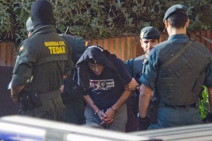 Agentes de la Guardia Civil conducen esposado a uno de los presuntos etarras detenidos en Villabona.