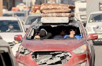 Un vehículo seriamente dañado es usado por una familia para huir del norte de la Franja de Gaza este viernes.