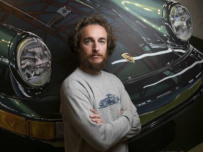 Manu Campa, pintor realista, fotografiado delante de una de sus pinturas de un Porsche.