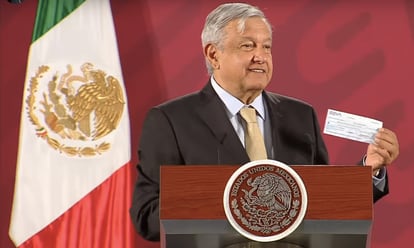 López Obrador muestra el cheque de la FGR para el Indep por 2.000 millones de pesos.