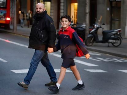 Unai García, favorable a vacunar a su hijo, Ander, camina de la mano del menor por el centro de Barcelona, este viernes