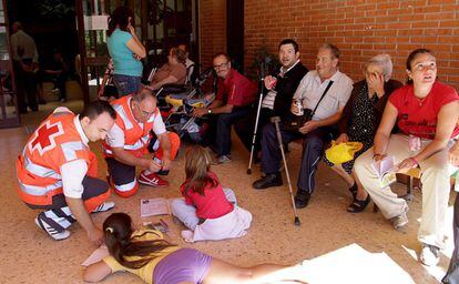 Voluntarios de la Cruz Roja entretienen a niños de Chulilla desalojados desde anoche al instituto de Villar del Arzobispo.