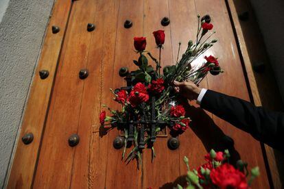 Un hombre deja flores en la puerta de donde salió el cadáver del difunto presidente de Chile, Salvador Allende, durante el golpe militar de 1973.