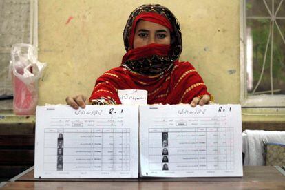 Una trabajadora muestra el censo electoral para las elecciones generales en un colegio electoral en Peshawar (Pakistán).