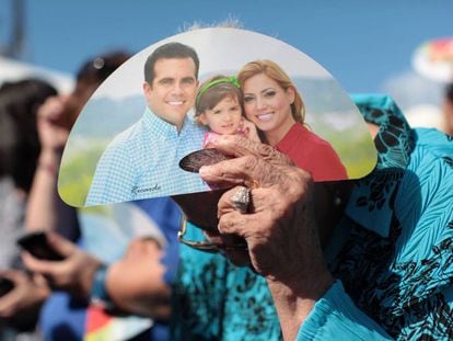 Una mujer se cubre del sol con propaganda del gobernador Rossell&oacute;.