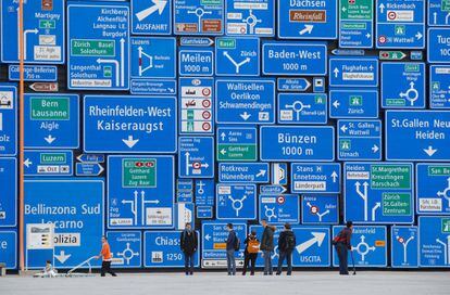 Visitantes se paran frente a una pared cubierta con señales de tránsito en el Museo Suizo del Transporte, en Lucerna (Suiza). 
