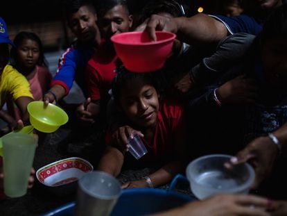 Indígenas venezolanos de la etnia Warao se congregan para distribuir alimentos antes de una sesión de cine el 6 de abril de 2019 en Pacaraima, Brasil.