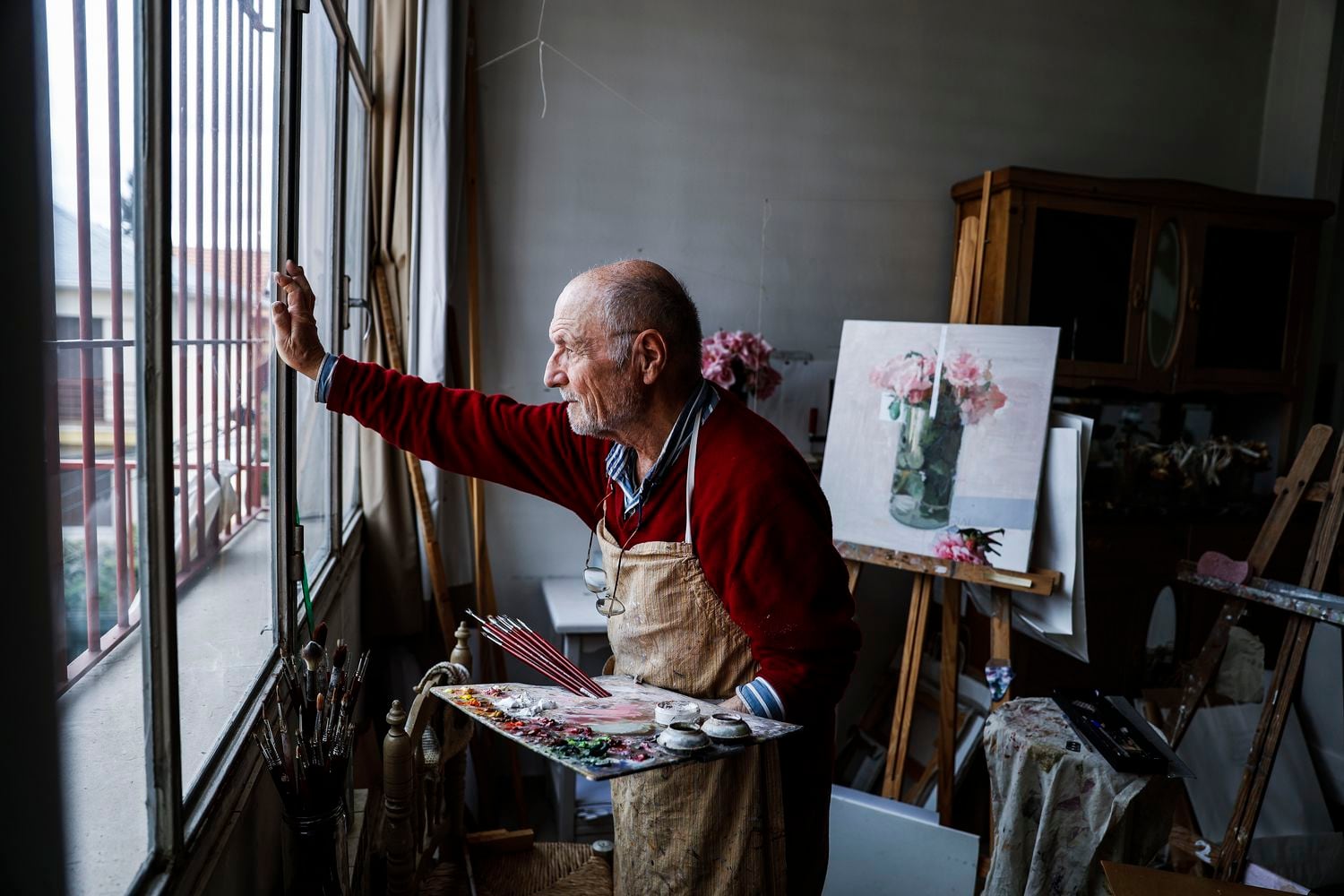 El pintor y escultor Antonio López contempla este jueves la calle vacía desde el estudio de su casa en Madrid.