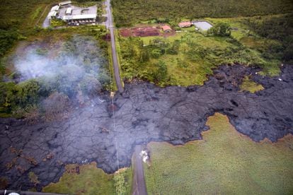 Más de 80 integrantes de la Guardia Nacional de EE UU vigilan el pequeño pueblo de Pahoa, en el estado de Hawái, amenazado por un río de lava del volcán Kilauea. En la imagen, vista aérea de la lengua de lava que ha cortado una carretera cerca de la ciudad de Pahoa, el 29 de octubre de 2014.