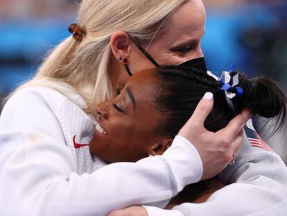 La gimnasta estadounidense Simone Biles (derecha), bronce en la final de barras, se abraza con su entrenadora, tras la final disputada el 3 de agosto en Tokio.