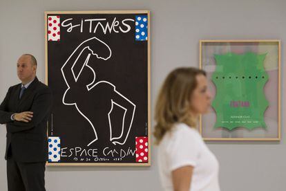 Visitantes del Museo Carmen Thyssen de Malaga, frente a las obras de Eduardo Arroyo (izquierda) y de Lucio Fontana en la exposición 'Carteles de artista. De Toulouse-Lautrec a Jeff Koons'.