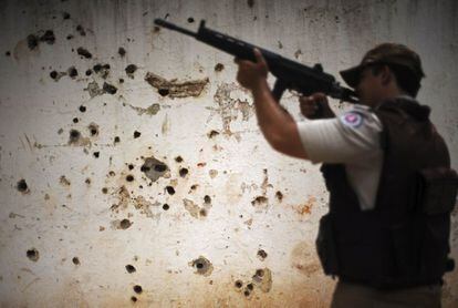 La policía patrulla más allá de la 'pared rifle' llamada así por los numerosos agujeros de balas tras los enfrentamientos entre la policía y los narcotraficantes de la zona de Amaralina, en Salvador de Bahía (Brasil).