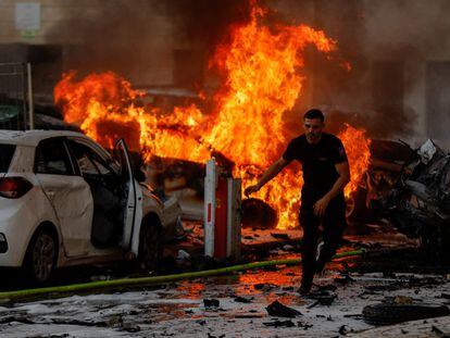 Un hombre huye de un incendio en la ciudad israelí de Ashkelón tras el lanzamiento de cohetes desde Gaza, este sábado.