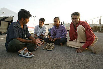 Varios de los inmigrantes llegados a Fuerteventura descansan junto a una tienda de la Cruz Roja.