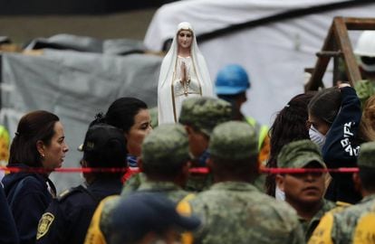 Una figura religiosa permanece durante las labores de b&uacute;squeda en el edificio de &Aacute;lvaro Obreg&oacute;n 