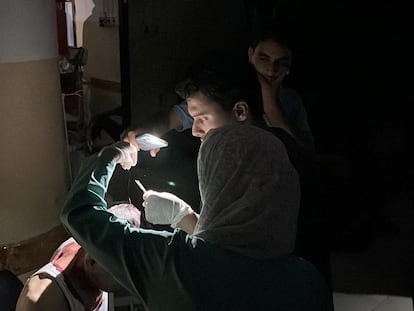 Un médico utiliza la linterna de un móvil para tratar a un paciente en un hospital de Gaza este lunes.