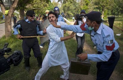Oficiales de policías pakistanís golpean a un manifestante en la capital Islamabad.