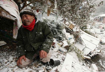 Un hombre llora frente a su casa destruida, donde su madre continúa sepultada por los escombros.
