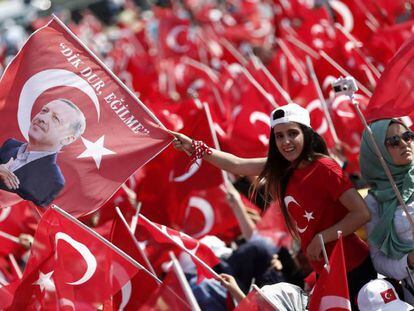 Dos jóvenes ondean banderas de Turquía y con la efigie de Erdogan.
