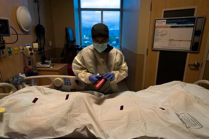 Un enfermero pega una calcomanía con la leyenda "Paciente covid" en una bolsa para cadáveres, en el Centro Médico Providence Holy Cross en Los Ángeles, el 14 de diciembre de 2021.