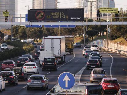 Activistas de Greenpeace durante una acción en la M-30 para denunciar la contaminación en Madrid.