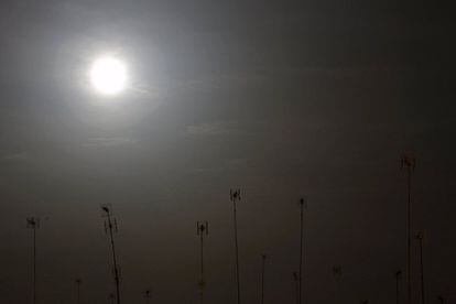 La luna fotografiada junto a varias antenas de televisión en Sevilla.