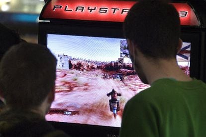 Dos jóvenes juegan con la Playstation en un centro comercial de Barcelona.