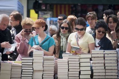 Asistentes a la feria de Sant Jordi mirando libros.