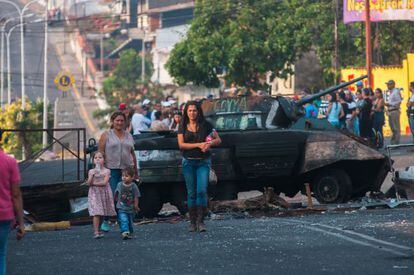 Varias mujeres caminan delante de un tanque utilizado para una de las barricadas que bloquean las calles de una de las ciudades del Estado de Táchira, cuna de las protestas.