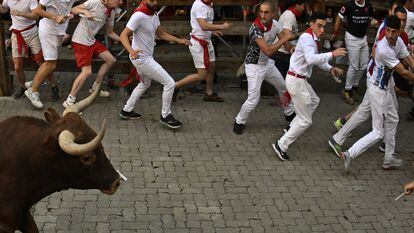 Los mozos, durante el octavo encierro de los Sanfermines, con toros de la ganadería de Miura, este jueves en Pamplona.