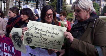 Dos mujeres sujetan un cartel en San Sebastián en el que reclaman más financiación para luchar contra la violencia machista.