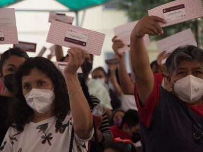 Un grupo de madres de estudiantes de secundaria sostiene tarjetas de la Beca para Empezar, en Ciudad de México.