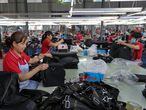 This photo taken on July 15, 2020 shows workers producing bags that will be exported at a textile factory in Huaibei in China's eastern Anhui province. - China's economy returned to growth in the second quarter, rebounding more strongly than expected from a historic contraction caused by the coronavirus outbreak, official data showed on July 16. (Photo by STR / AFP) / China OUT