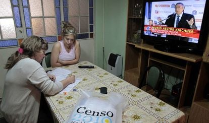An official carries out the census in a house in Rosario in 2010, while television reports the death of former President Néstor Kirchner.