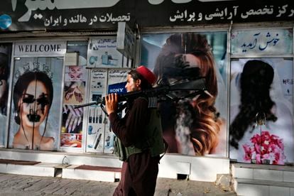 Un talibán pasa por delante de un salón de belleza con las imágenes de mujeres pintadas con aerosol, en Kabul, el pasado 18 de agosto.